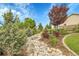 Beautiful landscaping with a dry creek bed and mature trees creates a serene setting at 8236 S Ireland Way, Aurora, CO 80016