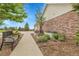 Well-manicured side yard with mature trees, lush plants, and a seating area at 8236 S Ireland Way, Aurora, CO 80016