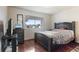 Bedroom with hardwood floors, a dresser with a television, and a large window view at 46 S Nome St, Aurora, CO 80012