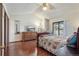 Spacious bedroom featuring a ceiling fan, wood floors, a mounted television, and a large window view at 46 S Nome St, Aurora, CO 80012