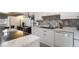 Bright kitchen features white cabinetry, stainless steel appliances, and a modern backsplash at 46 S Nome St, Aurora, CO 80012