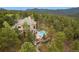 Aerial view of home with pool, patio, and deck areas surrounded by a dense forest at 2521 Juniper Ct, Golden, CO 80401