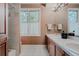 Bright bathroom featuring double sinks, tile floors, and a window with natural light at 2521 Juniper Ct, Golden, CO 80401