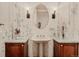 Stylish powder room with floral wallpaper, an oval mirror, sconce lighting, and pedestal sink at 2521 Juniper Ct, Golden, CO 80401