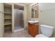 Bathroom featuring a glass enclosed shower, wooden vanity, light sconce, and built-in shelving unit at 12613 Knox Pt, Broomfield, CO 80020