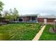 Spacious backyard featuring a large deck, lush lawn, and brick exterior of the home at 465 Salem St, Aurora, CO 80011
