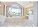 Light-filled bathroom with a large soaking tub under a large window, white cabinets and tiled flooring at 6254 S Riviera Ct, Aurora, CO 80016
