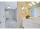 A bathroom featuring a sink with white cabinets and a large mirror, with an adjacent room with a closet and bedroom at 6254 S Riviera Ct, Aurora, CO 80016