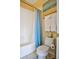 Cozy bathroom featuring a shower over tub combination, blue curtain, and decorative artwork at 6254 S Riviera Ct, Aurora, CO 80016
