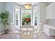 Cozy breakfast nook with white table set and bay window letting in natural light and a view to outdoors at 6254 S Riviera Ct, Aurora, CO 80016