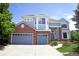 Charming two-story home with a well-manicured lawn, blue siding, red brick, and an attached two-car garage at 6254 S Riviera Ct, Aurora, CO 80016