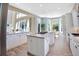Open concept kitchen with island, white cabinets, stainless steel appliances, and breakfast nook with large windows at 6254 S Riviera Ct, Aurora, CO 80016
