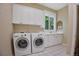 Well-lit laundry room with a washer, dryer, and built-in storage cabinets at 6254 S Riviera Ct, Aurora, CO 80016