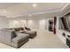 Basement living area with stylish seating, large windows, and a modern entertainment center for a cozy atmosphere at 6254 S Riviera Ct, Aurora, CO 80016