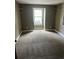 A neutral carpeted room with a window and high trim, well-lit with natural light at 14096 E Radcliff Cir, Aurora, CO 80015