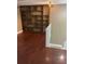 Spacious living room with built-in shelving, wood floors, and carpeted stairs to a second floor at 14096 E Radcliff Cir, Aurora, CO 80015