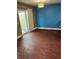 Bright living room featuring wood floors, access to the backyard, and a large window for natural light at 14096 E Radcliff Cir, Aurora, CO 80015