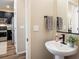 Stylish half-bathroom with a modern sink, vanity, mirror, lighting fixtures and a view of the kitchen at 1125 Anker Dr, Erie, CO 80516