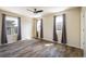 Clean bedroom features hardwood floors and three windows that provide ample natural light and gray curtains at 1125 Anker Dr, Erie, CO 80516