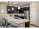 Modern kitchen features a breakfast bar with seating, sleek cabinets, stainless steel appliances, and granite countertops at 1125 Anker Dr, Erie, CO 80516