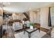 Open-concept living space with hardwood floors, dining area, and modern staircase at 1125 Anker Dr, Erie, CO 80516