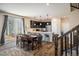 Open floor plan featuring dining area with table, kitchen with island, and stairs at 1125 Anker Dr, Erie, CO 80516