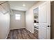 Empty walk-in closet with installed shelves, hardwood floors, a window, and a door to the main bedroom at 1125 Anker Dr, Erie, CO 80516