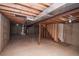 Unfinished basement with concrete floor and wooden ceiling beams at 2217 S Nome Ct, Aurora, CO 80014