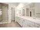 Bathroom featuring double sinks, a shower with glass door, and neutral tile at 2217 S Nome Ct, Aurora, CO 80014