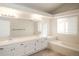 Bright bathroom with double sinks, a large mirror, and a tub at 2217 S Nome Ct, Aurora, CO 80014