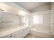 Bright bathroom featuring double vanity, large mirror, and bathtub at 2217 S Nome Ct, Aurora, CO 80014