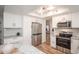 Bright kitchen features stainless steel appliances, recessed lighting, and white cabinetry throughout at 2217 S Nome Ct, Aurora, CO 80014