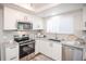 Modern kitchen with stainless steel appliances, white cabinets, and granite countertops at 2217 S Nome Ct, Aurora, CO 80014