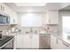 Well-lit kitchen with white cabinets, granite countertops, stainless steel appliances, and a subway tile backsplash at 2217 S Nome Ct, Aurora, CO 80014