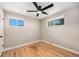 Bright bedroom with hardwood floors, neutral walls, a ceiling fan and two windows at 1150 Rosemary St, Denver, CO 80220