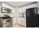 Kitchen with updated appliances, white cabinets, stainless steel oven and granite countertop at 1150 Rosemary St, Denver, CO 80220