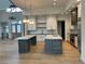 Spacious, open kitchen with modern appliances, two islands, and stylish lighting provides a functional design at 5841 Powell Rd, Parker, CO 80134