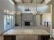 Open living room with stone fireplace, high ceilings, and kitchen view at 5841 Powell Rd, Parker, CO 80134