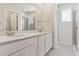 Bright bathroom featuring a double sink vanity, a large mirror, and a glass-enclosed shower at 14125 Deertrack Ln, Parker, CO 80134