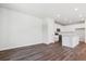 Spacious living room area adjacent to the kitchen, showcasing dark hardwood floors, and ample natural light at 14125 Deertrack Ln, Parker, CO 80134