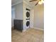 Convenient laundry area with stacked washer and dryer and tiled floors at 886 Summer Dr, Highlands Ranch, CO 80126