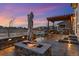 Outdoor space with a stone fire pit, grilling area, covered patio, and well-kept lawn at 745 Penstemon Dr, Henderson, CO 80640