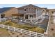 Sprawling fenced backyard featuring a built-in fire pit and an outdoor kitchen beneath a pergola at 745 Penstemon Dr, Henderson, CO 80640