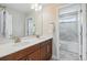 Bright bathroom featuring a double vanity, large mirror, and a separate shower/tub at 745 Penstemon Dr, Henderson, CO 80640