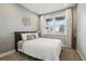 Inviting bedroom with a plush bed, textured wallpaper, and abundant natural light from the window at 745 Penstemon Dr, Henderson, CO 80640