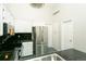 Bright kitchen with stainless steel appliances, white cabinetry, and contrasting dark countertops at 9617 W Chatfield Ave # E, Littleton, CO 80128