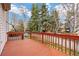 A spacious back deck with a red-stained wooden railing with a backyard at 5596 S Urban St, Littleton, CO 80127