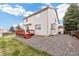 Exterior view of the back of the house, featuring a deck, gravel, and lush lawn at 5596 S Urban St, Littleton, CO 80127