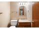 Half bathroom featuring a vanity with granite countertop, and a framed mirror at 5596 S Urban St, Littleton, CO 80127