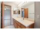 Bright bathroom featuring a single sink vanity, large mirror, and neutral wall color at 5596 S Urban St, Littleton, CO 80127